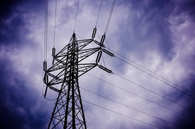 Elektrik kablolarının silüetiyle dramatik fırtınalı bulutlar, karartma