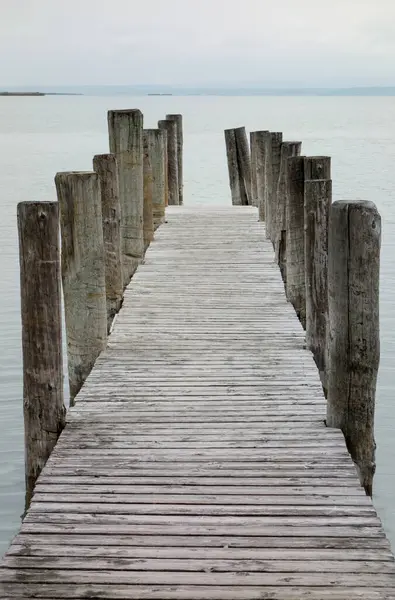 Soğuk havada gölün yanındaki ahşap iskele.