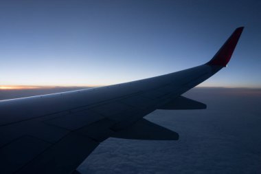 Gün batımında motorlu uçak kanadı