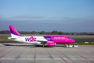KATOWICE, POLAND - 25 Ekim: Wizzair Havayolları şirketinin Airbus A320-232 uçağı Polonya 'nın Katowice Havaalanı' ndaki servis kamyonu tarafından çekildi