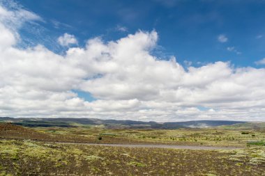 Kuru arazi ve mavi bulutlu gökyüzü ile İzlanda manzarası