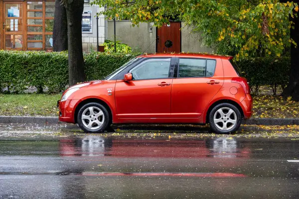 TOKAJ, HUNGARY - 27 Ekim 2023: Caddeye park edilmiş kırmızı Suzuki Swift RS hatchback arabasının yan görüntüsü 