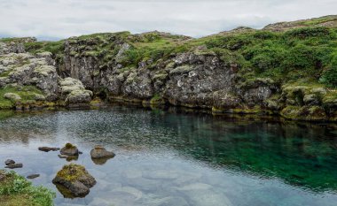 İzlanda 'da Thingvellir kilisesi yakınlarında küçük bir gök mavisi Peningagja gölü
