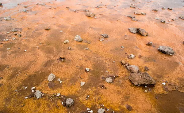 İzlanda 'da Geysir yakınlarında mineralli turuncu ıslak toprak.