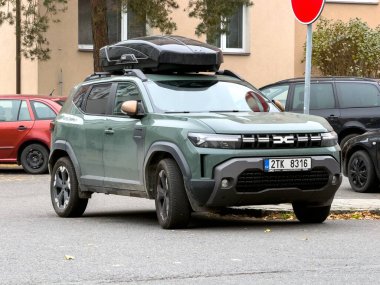 OSTRAVA, CZECHIA - 9 Kasım 2024: Yeşil Dacia Duster III P1310 Çatı kutusu caddeye park edilmiş