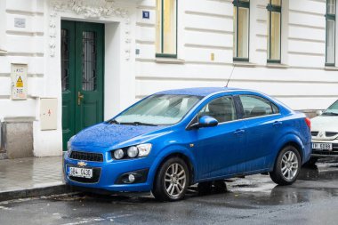 OSTRAVA, CZECHIA - 24 Kasım 2023: Mavi Chevrolet Aveo II T300 sedan araba yağmur altında sokağa park edildi