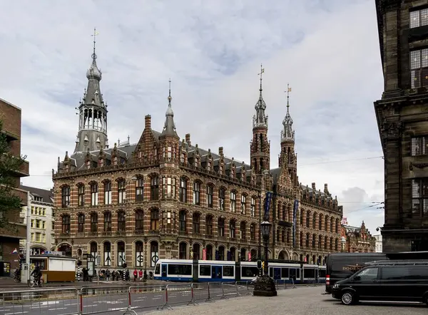 AMSTERDAM, NETHERLANDS - 7 Kasım 2013: Önünde mavi bir tramvay bulunan Hollanda 'daki ünlü Magna Plaza alışveriş merkezi