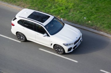 OSTRAVA, CZECHIA - 5 Nisan 2025: Hareket bulanıklığı etkisi olan beyaz BMW X5 G05 lüks SUV araba