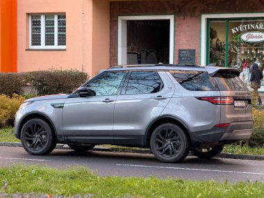 OSTRAVA, CZECHIA - 20 Kasım 2024: Land Rover Discovery V L462 SUV, caddeye park edilmiş, arka manzara