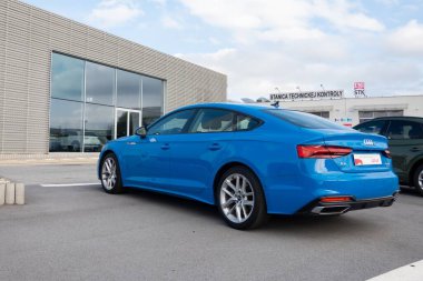 PRESOV, SLOVAKIA - 29 Ekim 2023: Blue Audi A5 Sportback 40 TDI Quattro F5 bar arabası galerinin önüne park edilmiş, dikiz manzaralı