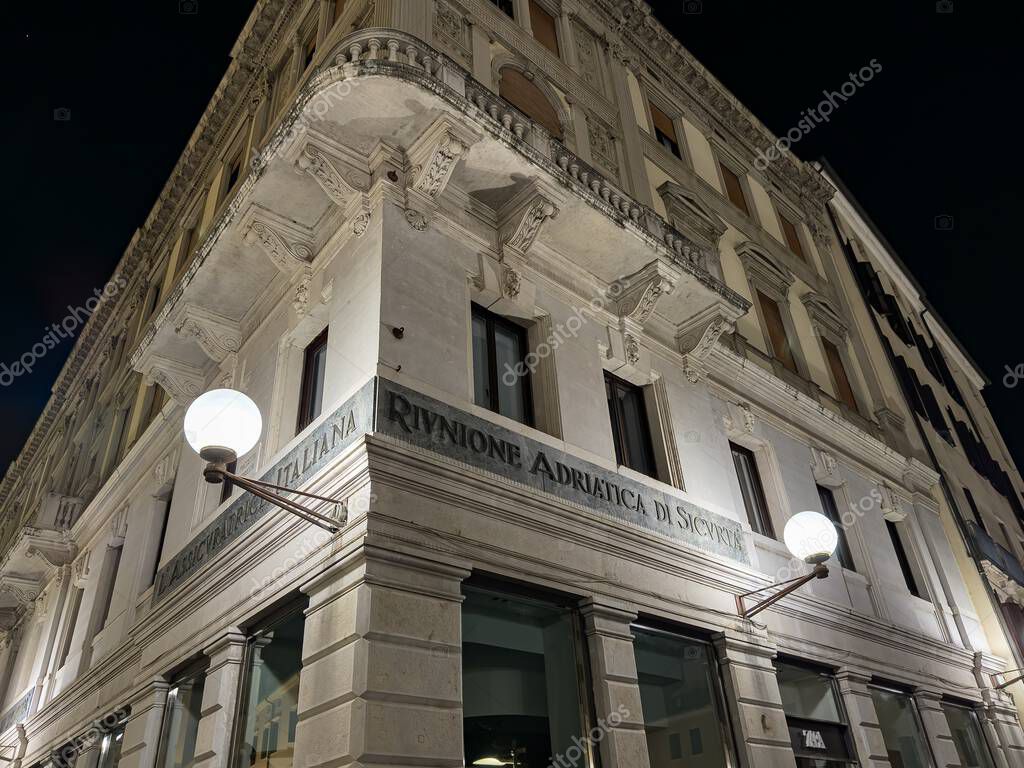 PADOVA, ITALY - OCTOBER 30, 2024: Branch of Riunione Adriatica di Sicurta bank office in Padova, Italy at night with lamps