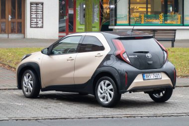 Ostrava, Çek Cumhuriyeti - 1 Şubat 2024: Kahverengi-siyah Toyota Aygo X mini hatchback arabası sokağa park edildi