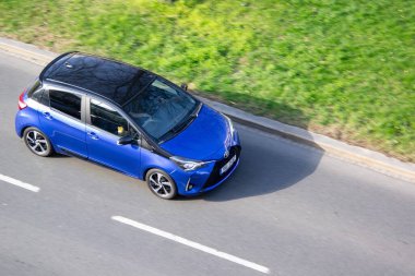 Ostrava, Çek Cumhuriyeti - 5 Nisan 2025: Mavi Toyota Yaris III XP130 hatchback arabası hareket bulanıklığı etkisi