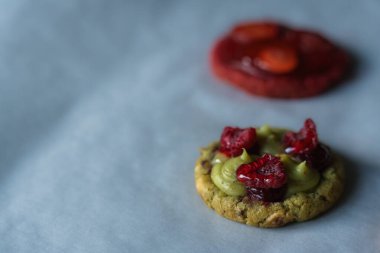 Ev yapımı Amerikan kurabiyesi, şam fıstığı ve ahududu. Taze ahududu, reçel ve fıstıklı kremayla süslenmiş. Uzayı kopyala Yüksek kalite fotoğraf