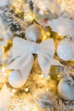 Karla kaplı Noel ağacı ve beyaz fiyonk ağacı süslemeleri. Sıcak, pırıl pırıl ışıklar. Yeni yıl ve Noel için süslemeler. Yüksek kalite fotoğraf