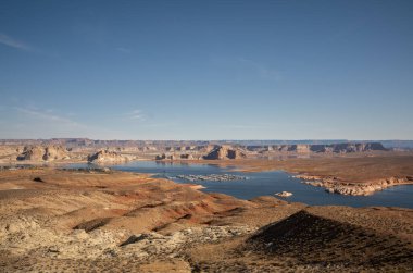 Powell Gölü 'nün geniş manzarası engebeli çöl manzarası ve Arizona' da berrak bir gökyüzü altında marina. Doğa keşfi, su tasarrufu ve çöl turizmi kavramı. Yüksek kalite fotoğraf