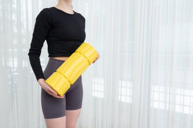 Vücut geliştirme için sarı köpük silindirli formalı kadın spor kıyafetleri giyiyor. Spor aletleri, vücut bakımı ve egzersiz sonrası terapisi kavramı. Yüksek kalite fotoğraf