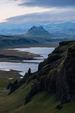 Güney İzlanda 'da volkanik kayalıklar ve nehir deltası dramatik gökyüzünün altında. Doğal enerji kavramı, keşif, saf güzellik, jeolojik güç ve İskandinav macerası. Yüksek kalite fotoğraf