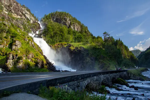 Latefossen, sarmal bir yolun kenarındaki kayalık uçurumlardan çarpıcı bir şelale akıyor. Bereketli bir yeşillik, güneşli bir günde huzurlu bir atmosfer yaratır..