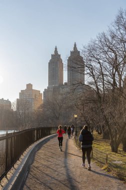 New York City, New York, ABD - 26 Şubat 2023: Kış soğuğu ortasında, koşucular Şubat ayında Central Park 'ın güneşli yollarında yürür..