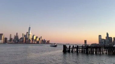 Hoboken, NJ, ABD, Mar 3, 2025: Altında Jersey City ve Manhattan silueti olan Hoboken Feribot Terminali 'ne yaklaşan panoramik manzara.