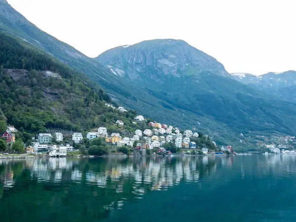 Odda, Norveç 'teki renkli evler sakin Hardangerfjord' u yansıtıyor. Etrafı yüksek dağlarla çevrili, alacakaranlıkta doğal güzellikleri sergiliyor..