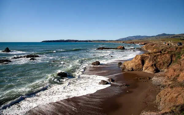 Kaliforniya, Kambriya 'da sakin bir kıyı şeridi, dalgaların Pasifik Sahil Otobanı' nın yanındaki kayalara çarptığı kıyı şeridi boyunca uzanır.