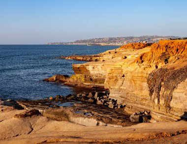 Kaliforniya 'nın engebeli kıyı şeridinde sıcacık renklerle Sunset Cliffs, San Diego, CA' da Alacakaranlık. 