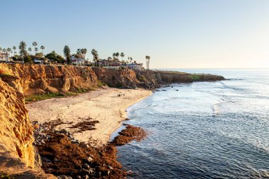 Güneş batarken, San Diego 'daki Sunset Cliffs okyanustan yansıyan altın ışıkla ve uçurumları aydınlatan gerçek güzelliğini gözler önüne seriyor.