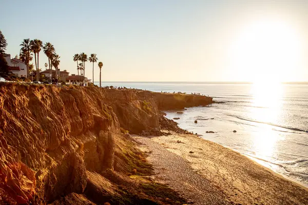 San Diego 'daki Sunset Cliffs' in dramatik kıyı şeridi güneş batarken altın renklerde parlıyor ve kayaların üzerinde uzun gölgeler oluşturuyor.