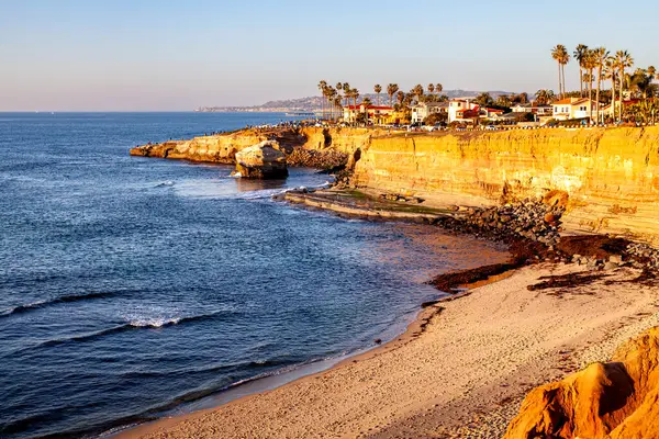 Altın saatin sıcacık parıltısı engebeli kayalıkları ve dalgaları aydınlatıyor. Sunset Kayalıklarına çarpıyor. Saf güzellikler sergiliyor..