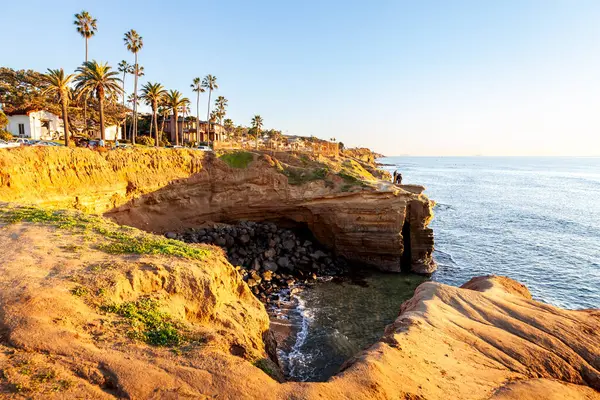 Sunset Cliff 'te yükselen kayalar ve gizli koylar alacakaranlığın yumuşak, altın ışığıyla güçlendirilmiş çarpıcı bir manzara yaratır.