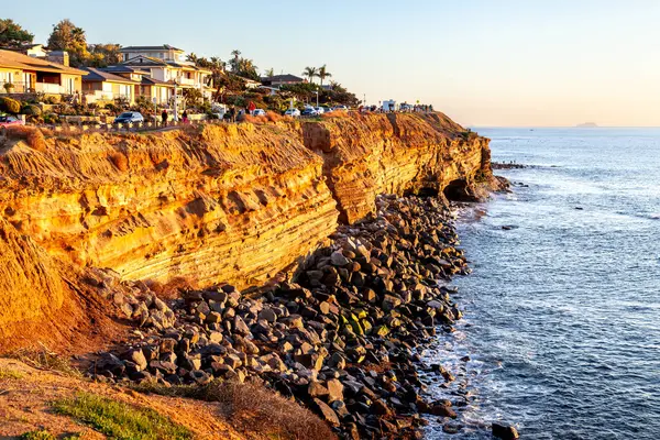 Güneş batarken kayalıklar parlak altın içinde parlıyor, Sunset Cliffs 'in kayalık kıyılarında dramatik gölgeler bırakıyor.