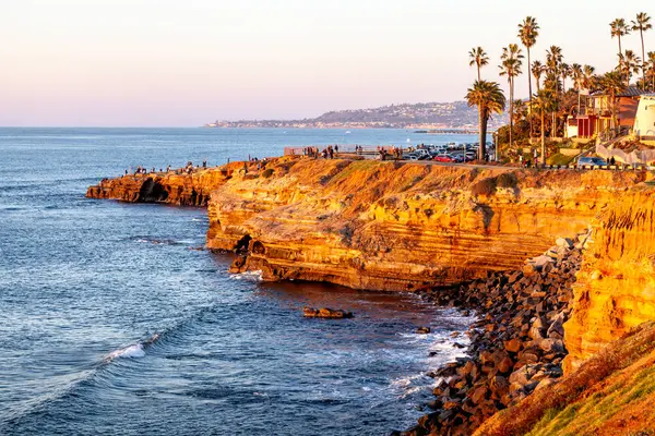 Günün son ışığı kayalık sahilde dans ediyor. Güneş yavaşça Sunset Cliffs, San Diego, CA 'da batıyor.