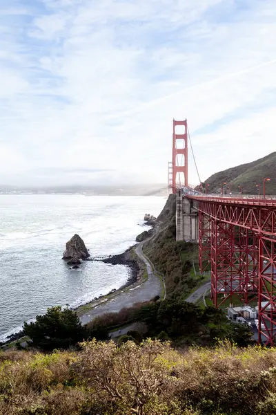 Golden Gate Köprüsü, körfez boyunca kayalık kıyı şeritleriyle çevrili görkemli bir şekilde uzanır. Mavi gökyüzü çarpıcı manzarayı güzelleştiriyor, turistleri ve yerlileri davet ediyor.