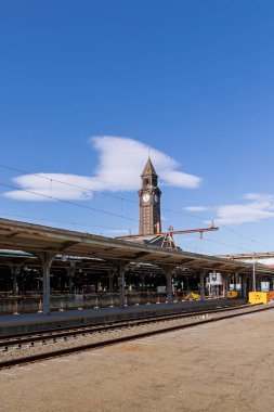 Açık gökyüzü ve klasik tren istasyonu mimarisi tarafından çerçevelenmiş Hoboken Terminali 'nin nehir kenarındaki yürüyüş yolundan ikonik saat kulesinin görüntüsü.
