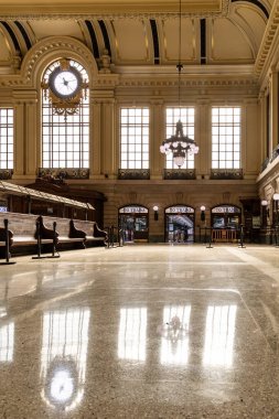 Hoboken, NJ, ABD - 19 Mayıs 2025: Cilalı zemin Hoboken Terminalleri 'nin kapılarındaki avize ve pencereleri tren rayları için bekleyen alanları yansıtıyor.