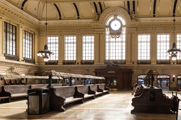 Hoboken, NJ, ABD - 19 Mayıs 2025: Güneş ışığı Hoboken Terminali 'nin geniş bekleme salonunu dolduruyor, büyük saat, ahşap banklar ve avizeler vurgulanıyor.