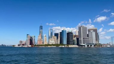 New York City, New York, ABD 6 Ekim 2024. Staten Island feribotu açık bir günde Lower Manhattan 'daki terminale yakındır. Bir Dünya Ticaret Merkezi ve gökdelenler işlek limanın arkasında dimdik duruyorlar..