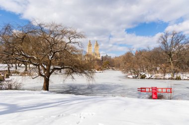 Central Park 'ta kar örtülü bir manzara. Şubat 2025' te parçalı bulutlu bir gökyüzünün altında ikonik binalar yükseliyor..