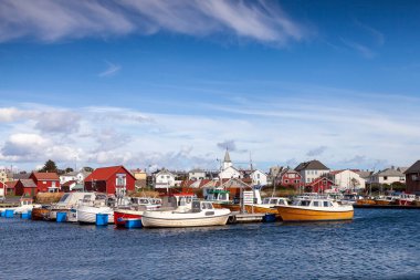 Borhaug, Lista 'daki bir Norveç liman sahnesinde teknelerle dolu bir rıhtım var. Küçük beyaz bir kilise, parlak bir gökyüzünün altında klasik kırmızı ve beyaz evlerin arasında yer alır..
