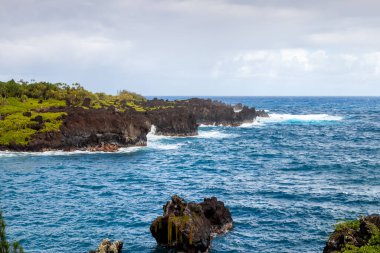 Güçlü dalgalar Hana 'daki Waianapanapa' daki volkanik kayalıklara çarparak Mau 'ların doğal güzelliğini gözler önüne seriyor. Hawaii 'den ham doğa sahnesi. 