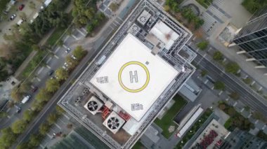 Santiago, Şili 'nin hareketli iş bölgesindeki yüksek katlı bir binanın çatısındaki helikopter pistini çekerken çekilen alçalan bir hava görüntüsü. Helikopter pisti belirgin bir şekilde sarı içinde H ile işaretlenmiş.