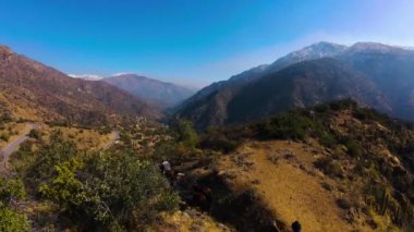 FPV insansız hava aracı görüntülerinin heyecanını yaşayın. Dönen dağ patikası boyunca at kovalamaca hareketlerini yakalayın. Videoda engebeli vadileri, yemyeşil bitkileri ve uzak diyarları olan canlı manzaralar sergileniyor.