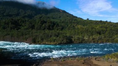 Bu akan nehrin nefes kesici görüntüsüyle kendini doğanın sakin ama güçlü güzelliğine daldır. Etrafı yemyeşil ormanlarla ve görkemli dağ tepeleriyle çevrili bu canlı manzara