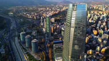 Güney Amerika 'nın en uzun gökdeleni Gran Torre Santiago' nun üstünden aşağıya bakan insansız hava aracı görüntüleri. Video, cam yapısı ve yoğun kentsel manzarasıyla kulenin tepesini gösteriyor.
