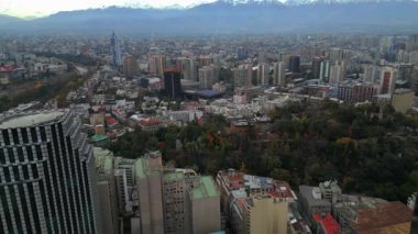 Santiago Şili 'nin yukarısından, Cerro Santa Lucia' nın yanından geçen hava görüntüleri. Yeşil tepe, modern gökdelenler ve tarihi mahallelerle çevrili yoğun şehir manzarasının ortasında duruyor.