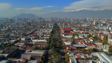 Santiago Şili 'nin insansız hava aracı görüntüleri, arka planda And Dağları ile modern şehir siluetine giden yerleşim yerlerini gösteriyor. Kompozisyon aradaki karşıtlığı vurgular