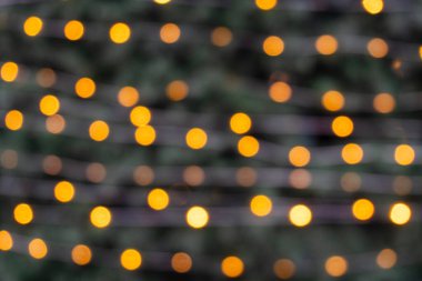 Minimalist bir çelenk, Noel ağacında bulanık bir ışık, kış tatillerinin sıcacık anlarını hatırlatıyor..