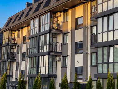 Şehrin yeşil bölgesinde yer alan, modern tasarımı, büyük pencereleri ve balkonları olan beş katlı yeni bir bina..